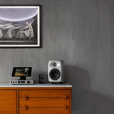 Undentia AB Genelec G Three active speaker in silver on a wooden sideboard with a tablet and framed wall art