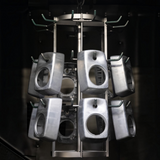 Undentia AB G Two active speaker enclosures hanging on a metal rack during the manufacturing process