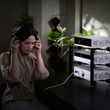 Woman listening to headphones with Undentia AB Matrix Audio NA-1 desktop amplifier system in a modern home studio