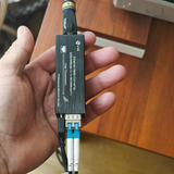 Undentia AB micro media converter held in hand, showing compact black design with SFP module and network cables