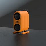 Undentia AB AKu Onar active speaker in bright orange with dual TeXtreme drivers and a central tweeter on a stand.
