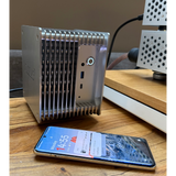 Undentia AB Cirrus7 SE silver passive-cooled music server with finned aluminum chassis next to a smartphone.